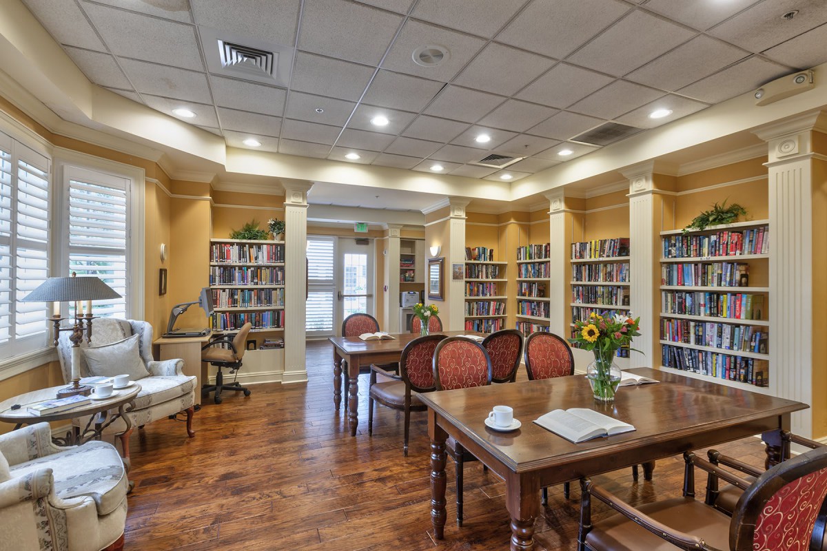 A cozy library reading room with comfortable seating and bookshelves.