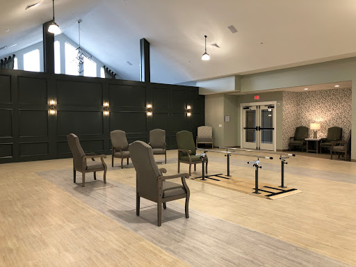 A spacious lounge area featuring modern chairs and tables, illuminated by natural light.
