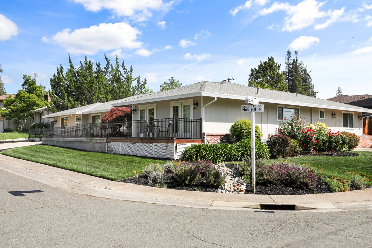 A suburban house with well-maintained landscaping on a clear day.