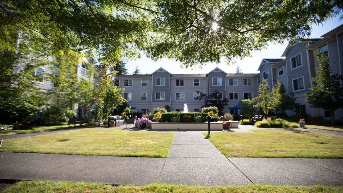 A picturesque view of a residential building surrounded by a well-kept garden and pathway.