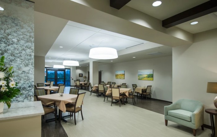A modern dining area with neatly arranged tables and chairs, complemented by elegant lighting and decor.