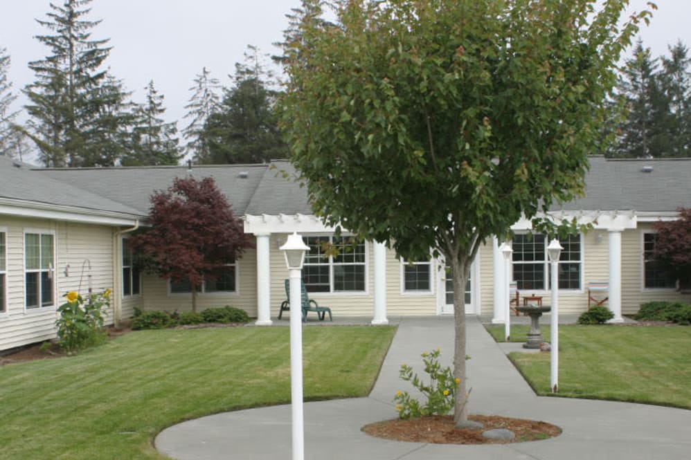 A house with a well-maintained yard featuring trees and a pathway.