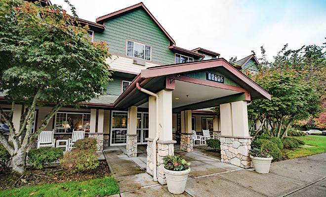 A view of a residential building entrance with a covered walkway.