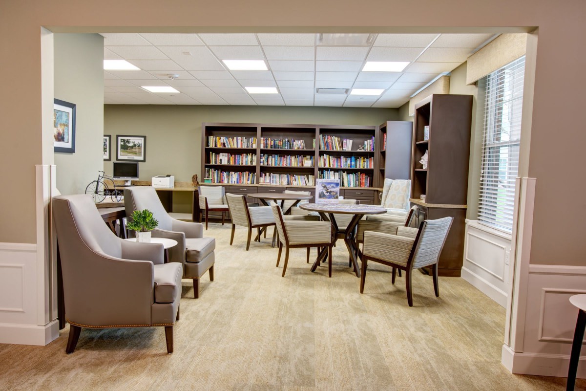A cozy library with comfortable seating and bookshelves filled with books.