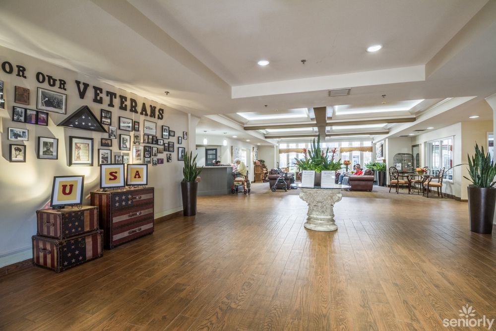 A spacious lobby with a veterans-themed decor, featuring photo displays and comfortable seating.