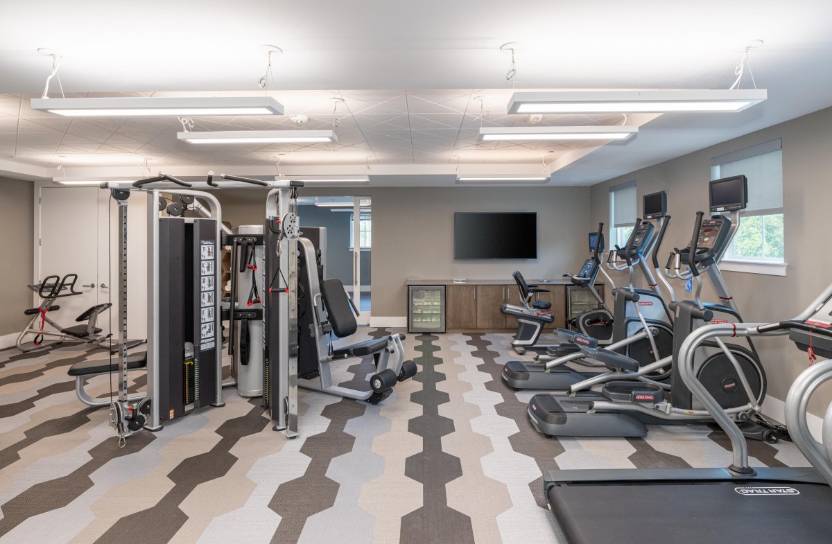 A modern gym equipped with various exercise machines, including treadmills and weightlifting equipment.