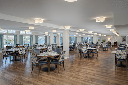 A spacious and elegantly designed dining area featuring wooden floors and modern furnishings.