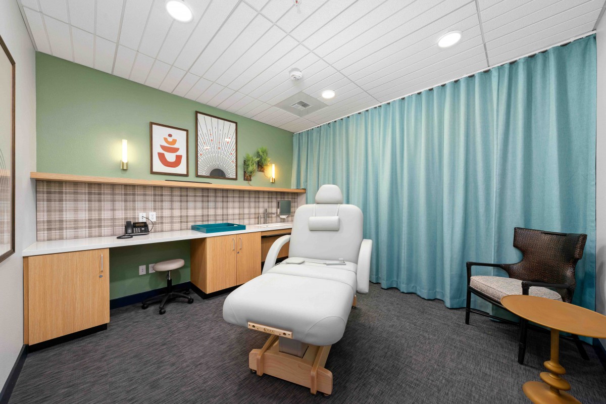 A well-organized medical treatment room featuring a comfortable treatment chair and modern decor.