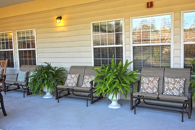 A cozy patio with comfortable seating and lush greenery.