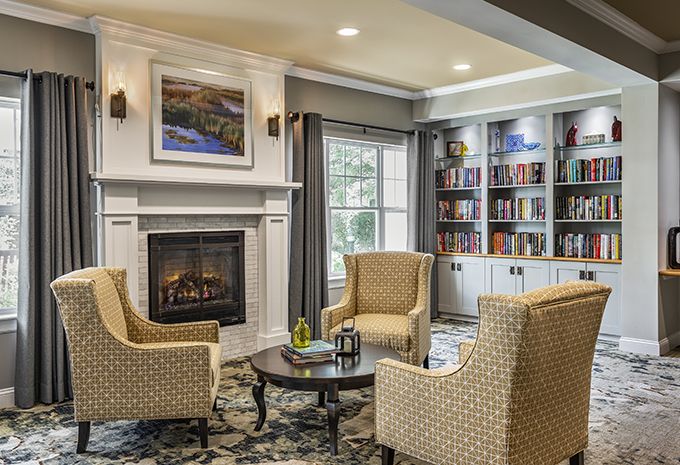 A cozy living room with a fireplace and bookshelves.
