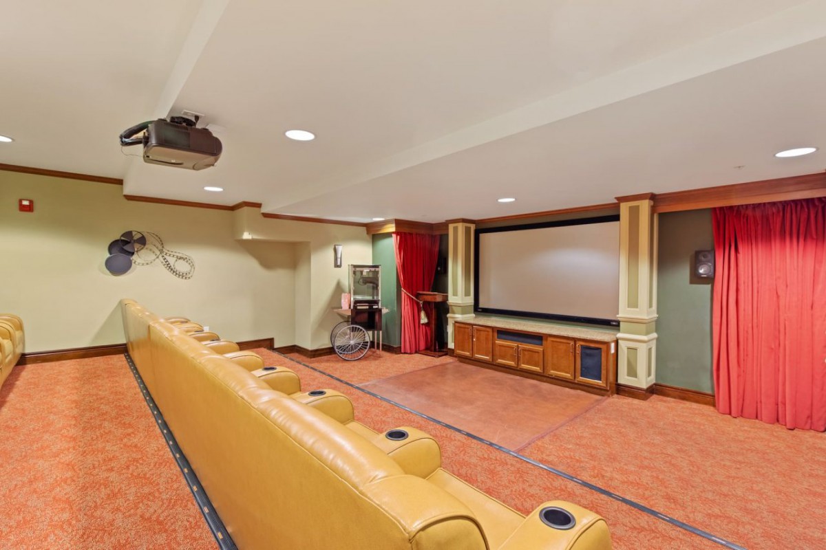 A cozy home theater room with a large screen and comfortable seating.