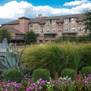 A beautiful hotel surrounded by lush gardens and vibrant flowers.