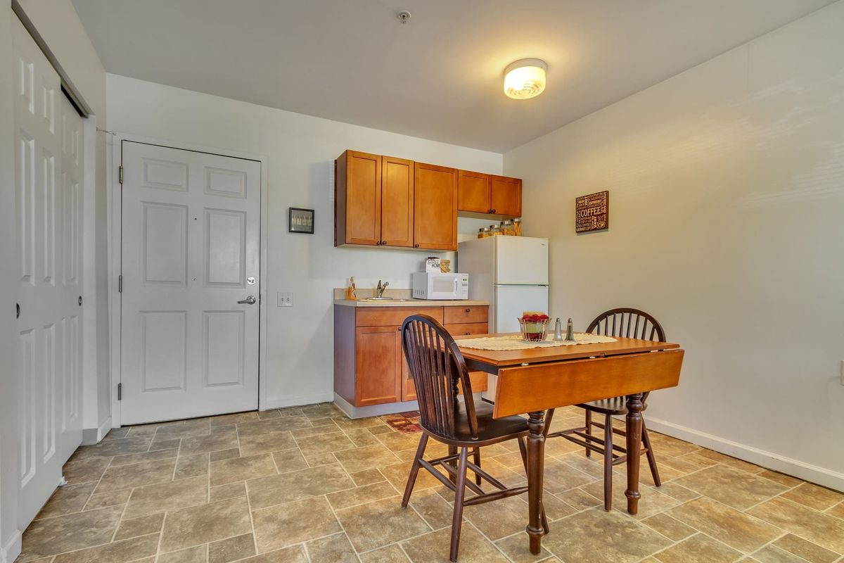 A cozy kitchen with a small dining area featuring a wooden table and chairs.