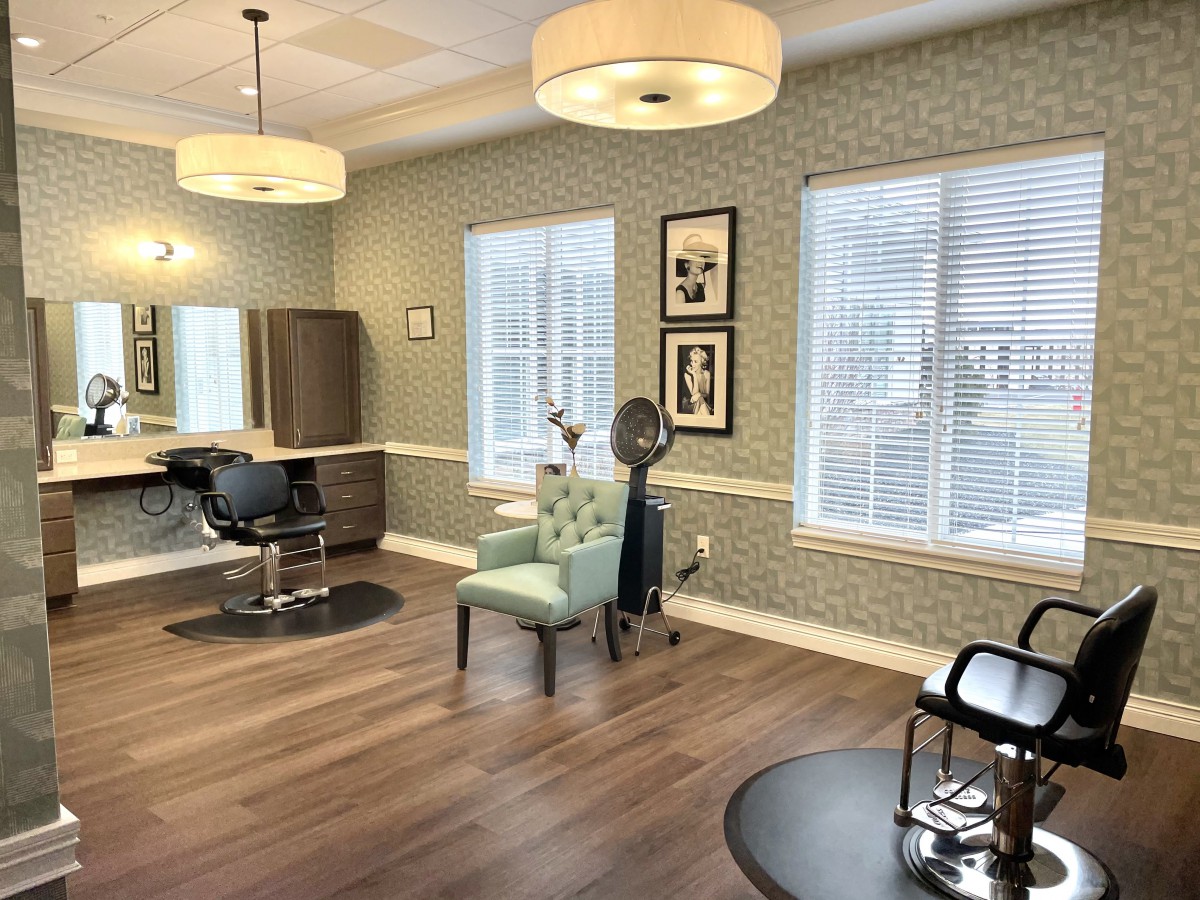 A well-appointed hair salon interior with stylish chairs and mirrors.