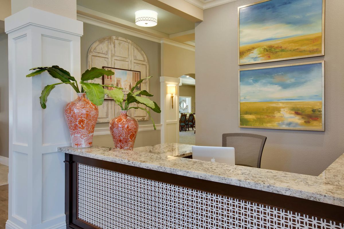 A modern reception area featuring a stylish desk with decorative vases and contemporary artwork.