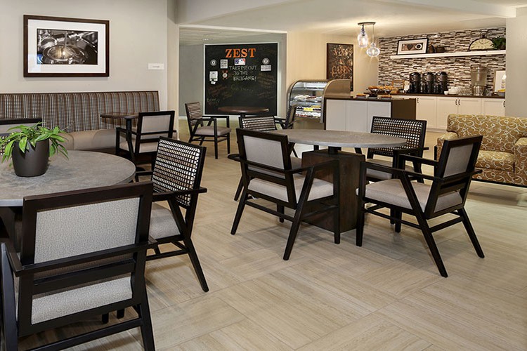 A cozy cafe interior featuring several tables and chairs, perfect for relaxing with a cup of coffee.