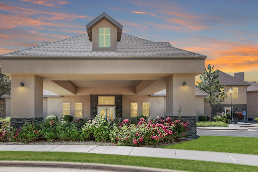 A welcoming residential building with lush landscaping at dusk.