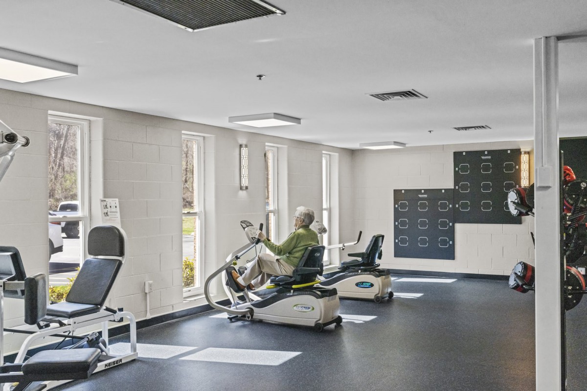 A person using exercise equipment in a well-lit gym.