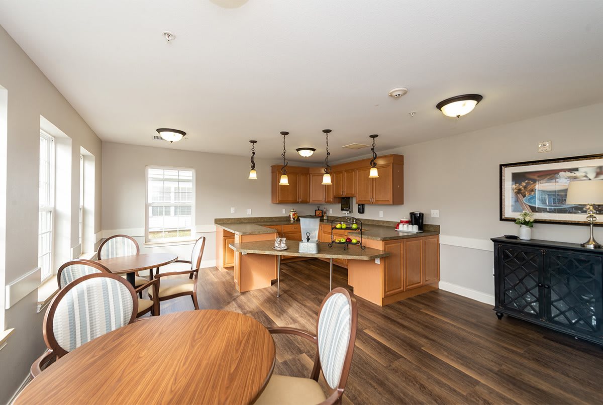 A modern kitchen and dining area featuring pendant lighting and wood flooring.