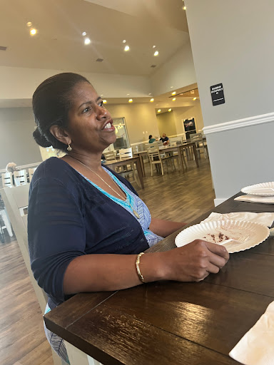 A woman enjoying a meal in a cozy restaurant, engaged in conversation.