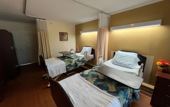 A view of a hospital room with two beds and medical equipment.