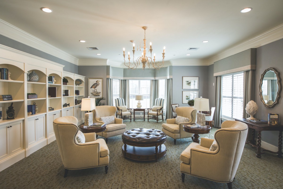 A spacious living room with elegant furniture and a chandelier.