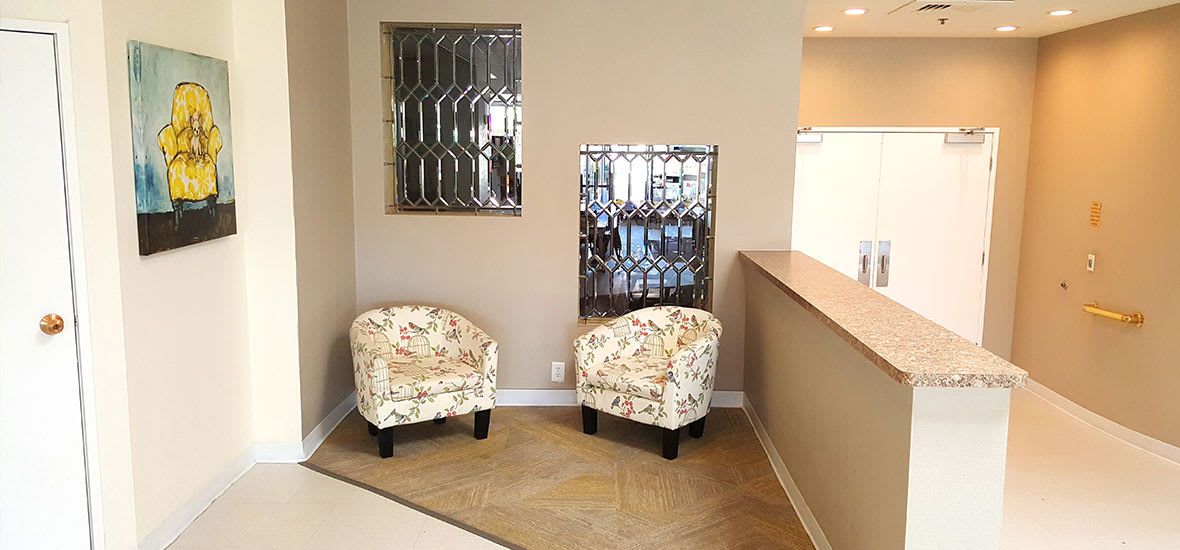 A cozy seating area with two patterned chairs and decorative mirrors on the wall.