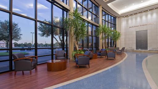 A cozy lounge area with comfortable seating and large windows overlooking a serene water view.