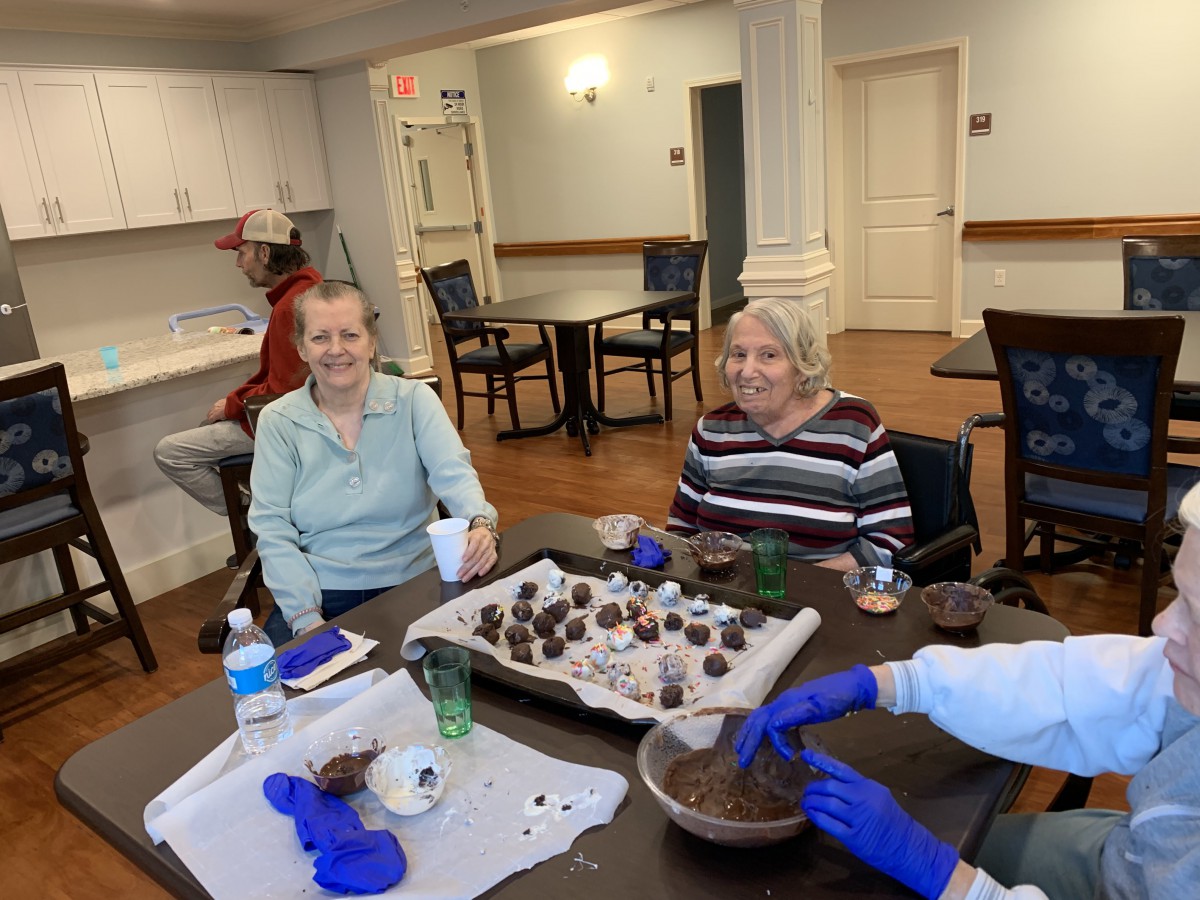 A group of elderly individuals engaged in a crafting activity at a community center.