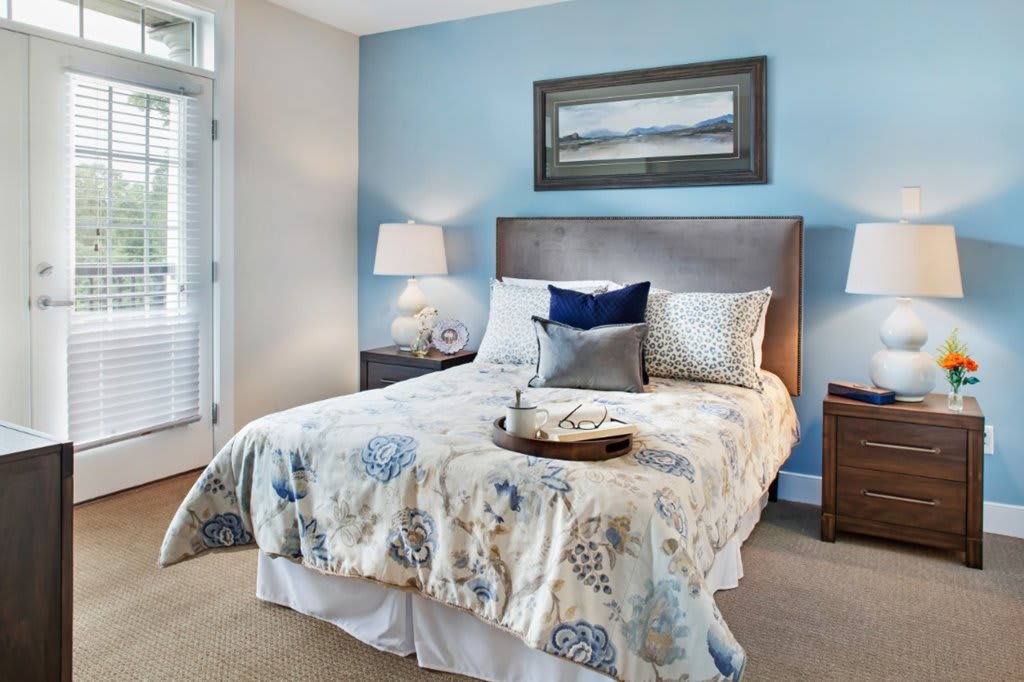 A cozy bedroom with a neatly made bed, soft lighting, and tasteful decor.