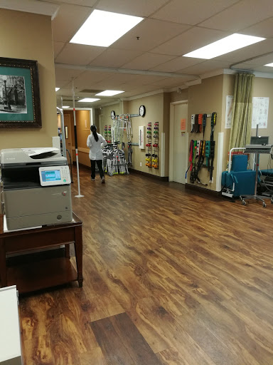 A view of the interior of a medical rehabilitation facility, showcasing a spacious walking area and healthcare equipment.