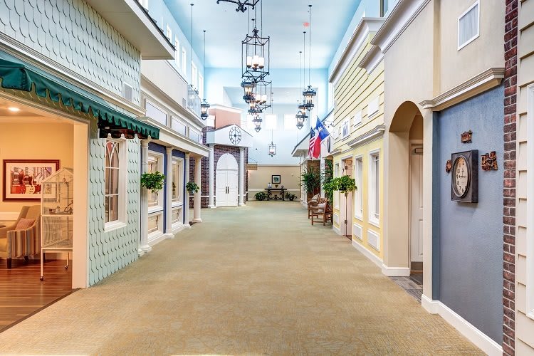 A vintage-style indoor hallway resembling a quaint street with decorative lights and flags.