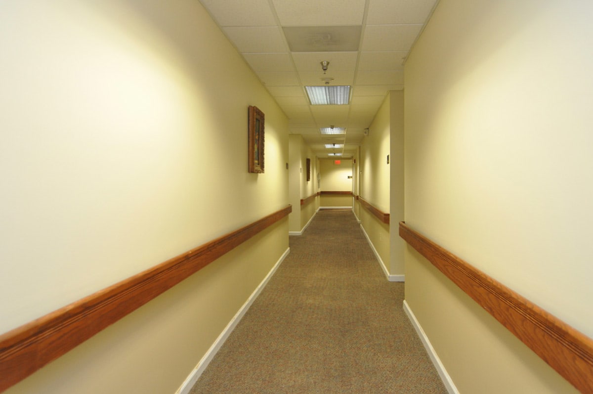 An empty hallway with handrails and ceiling lights.