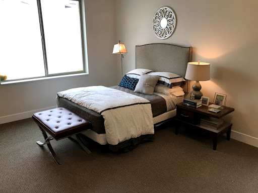 A cozy bedroom featuring a neatly made bed, stylish lamps, and a touch of modern decor.