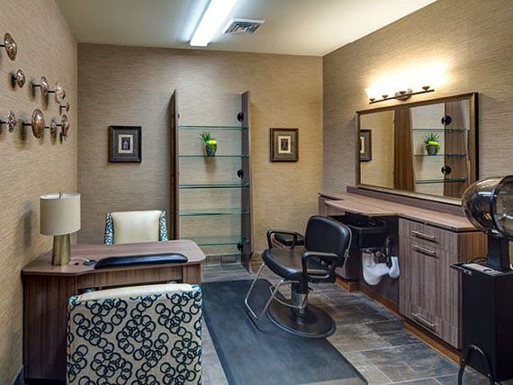 A cozy salon interior with a styling chair, mirror, and decorative elements.