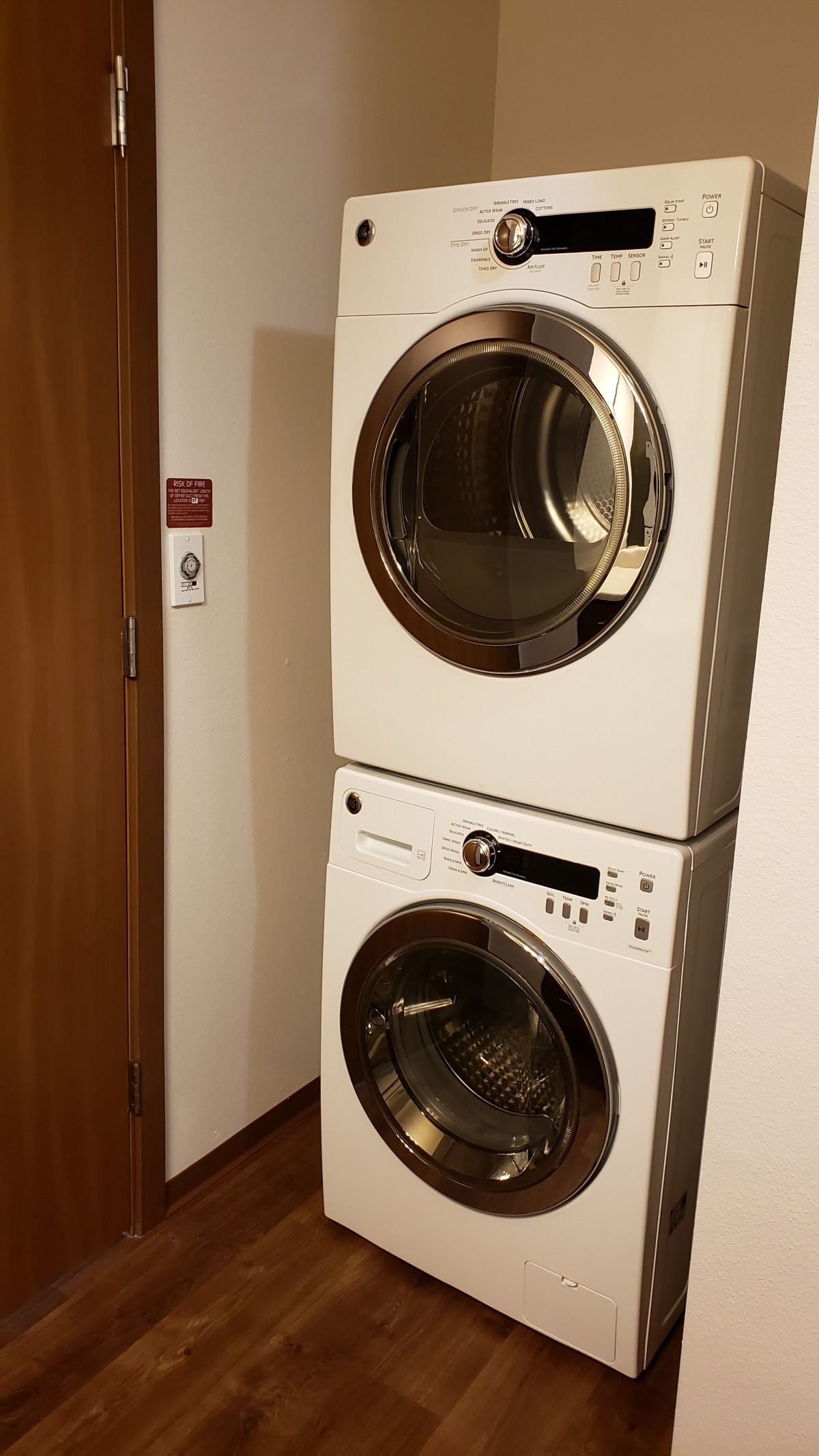 Stacked washing machine and dryer in a laundry area.