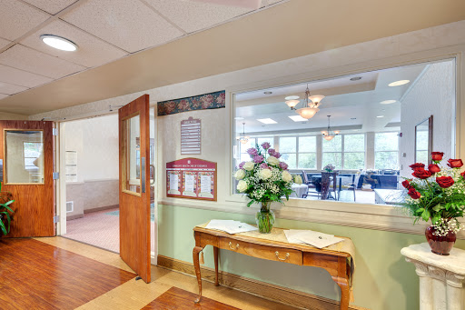 A cozy lobby area featuring a flower arrangement on a wooden table, welcoming visitors with an inviting atmosphere.
