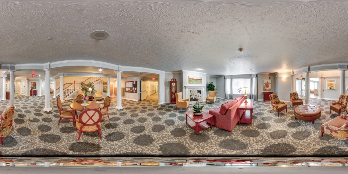 A modern and spacious living room with comfortable seating and bright lighting.