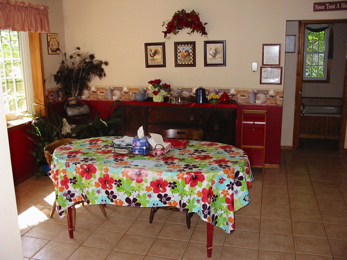 A dining room with a colorful floral-patterned tablecloth on the table.