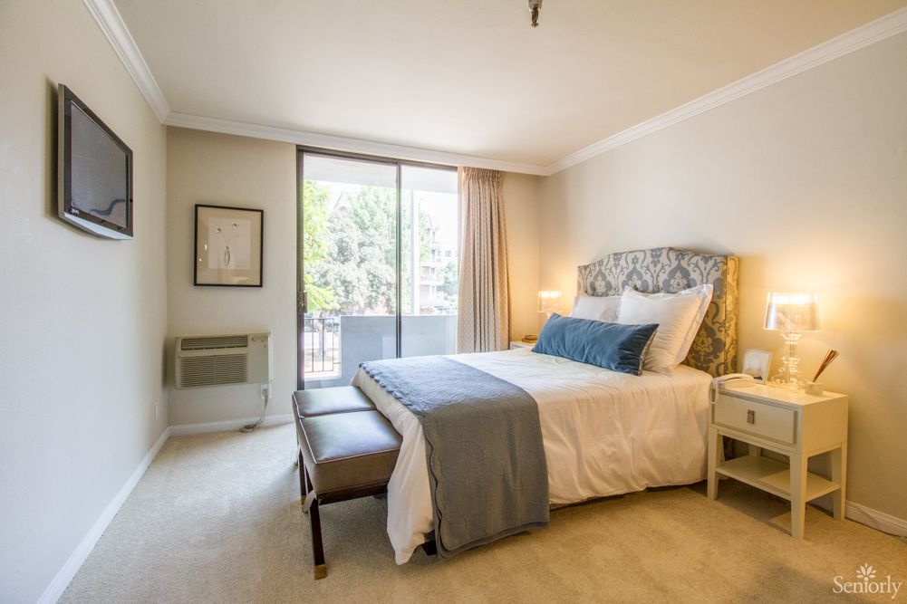 A modern and cozy bedroom with elegant decor and abundant natural light.