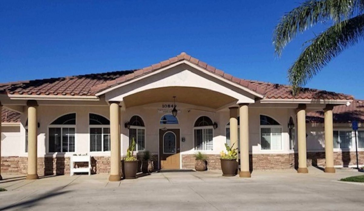 A residential building with a decorative entrance and columns under a clear blue sky.