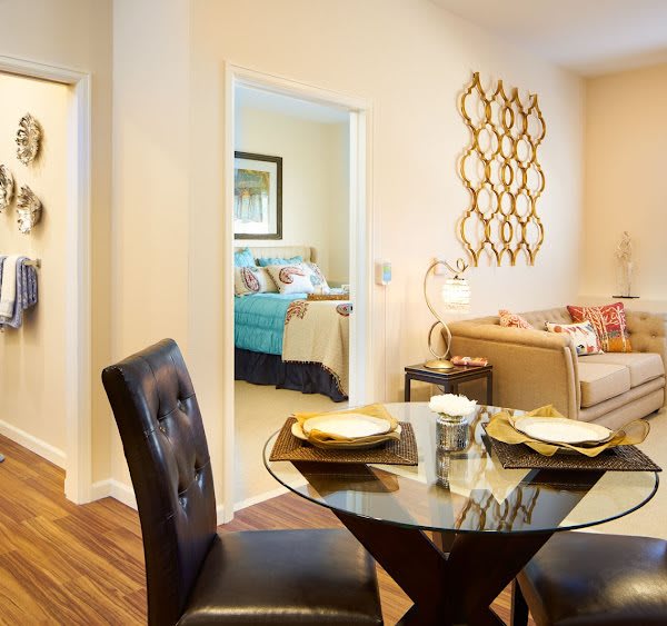 A cozy modern living space with a dining area and adjacent bedroom.