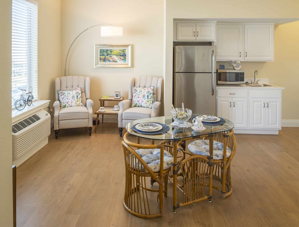 A cozy living and dining area with elegant furniture and a small kitchenette.