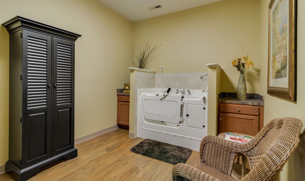 A cozy bathroom featuring a walk-in bathtub with wooden flooring and cabinets for storage.