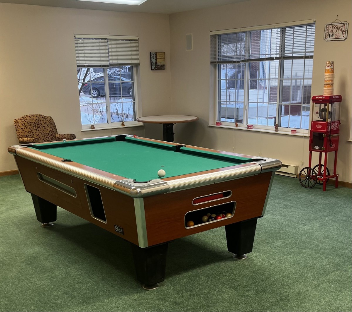 A cozy game room featuring a pool table and carpeted flooring.