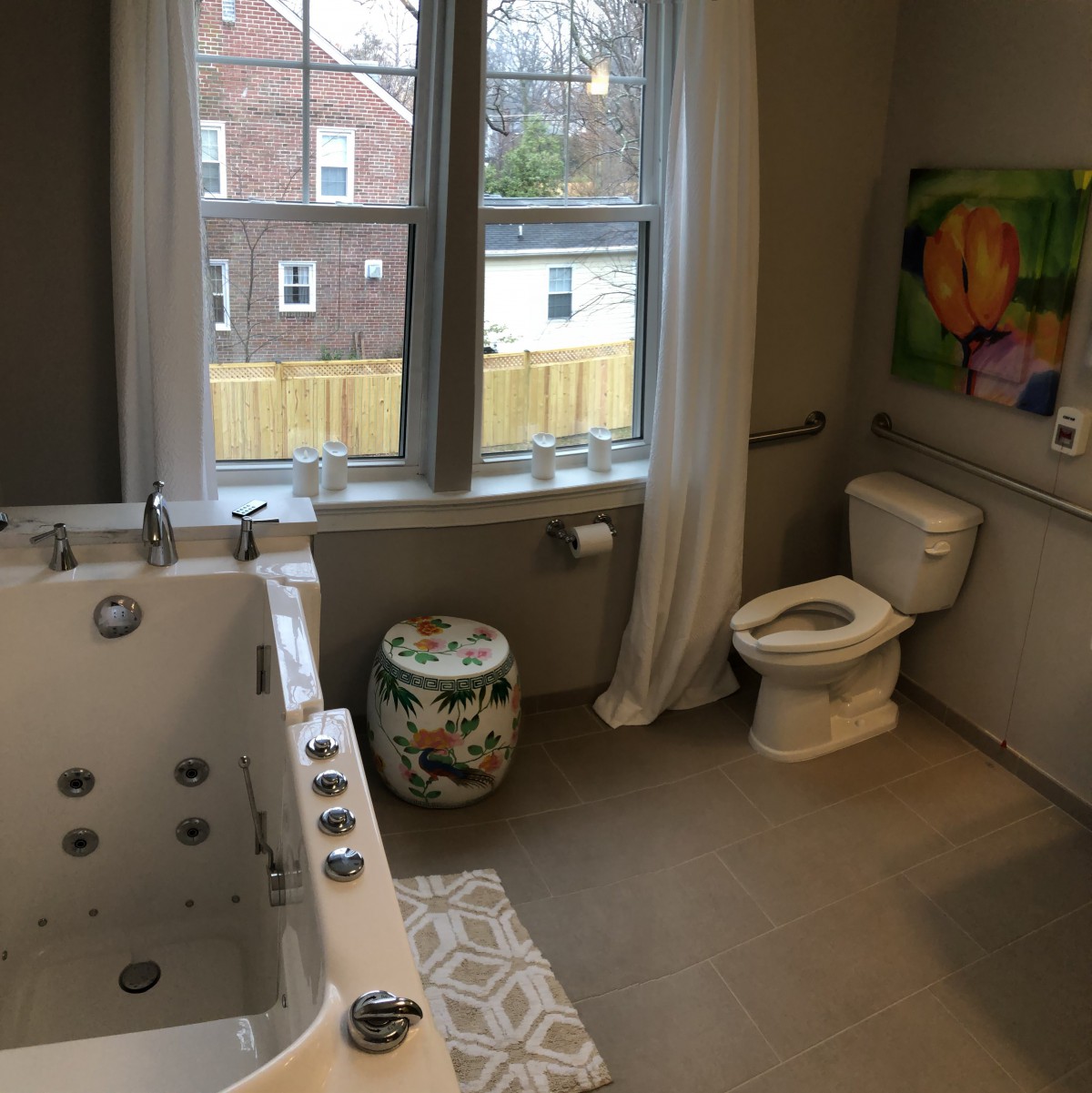 A spacious bathroom with a large bathtub and a window view.