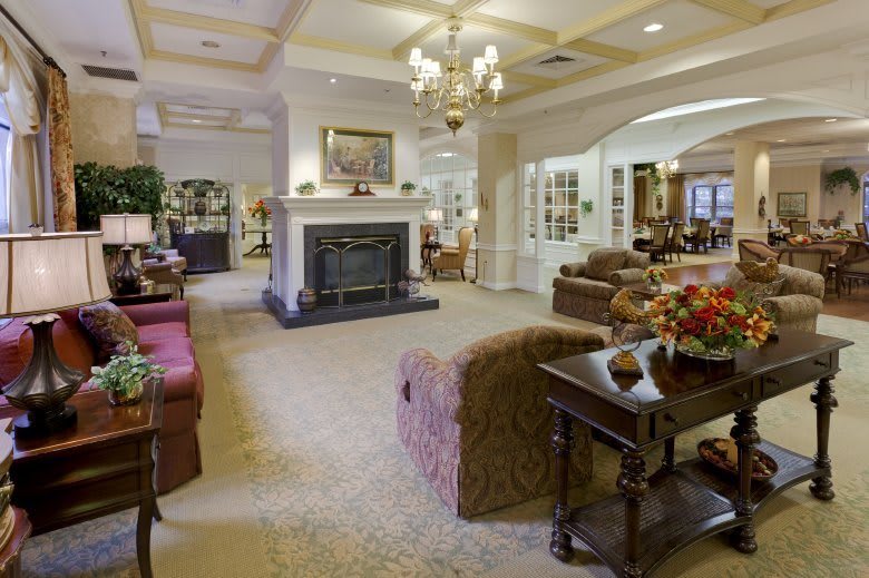 A cozy living room with traditional decor, featuring a fireplace and elegant furnishings.