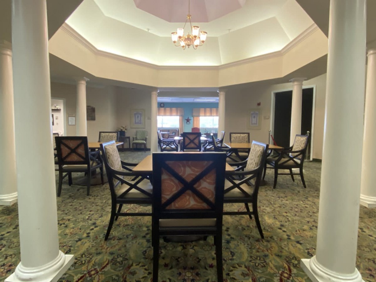 A spacious room with a central table surrounded by chairs under a dome ceiling.