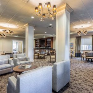 A spacious and elegantly designed lounge with comfortable seating and chandeliers.