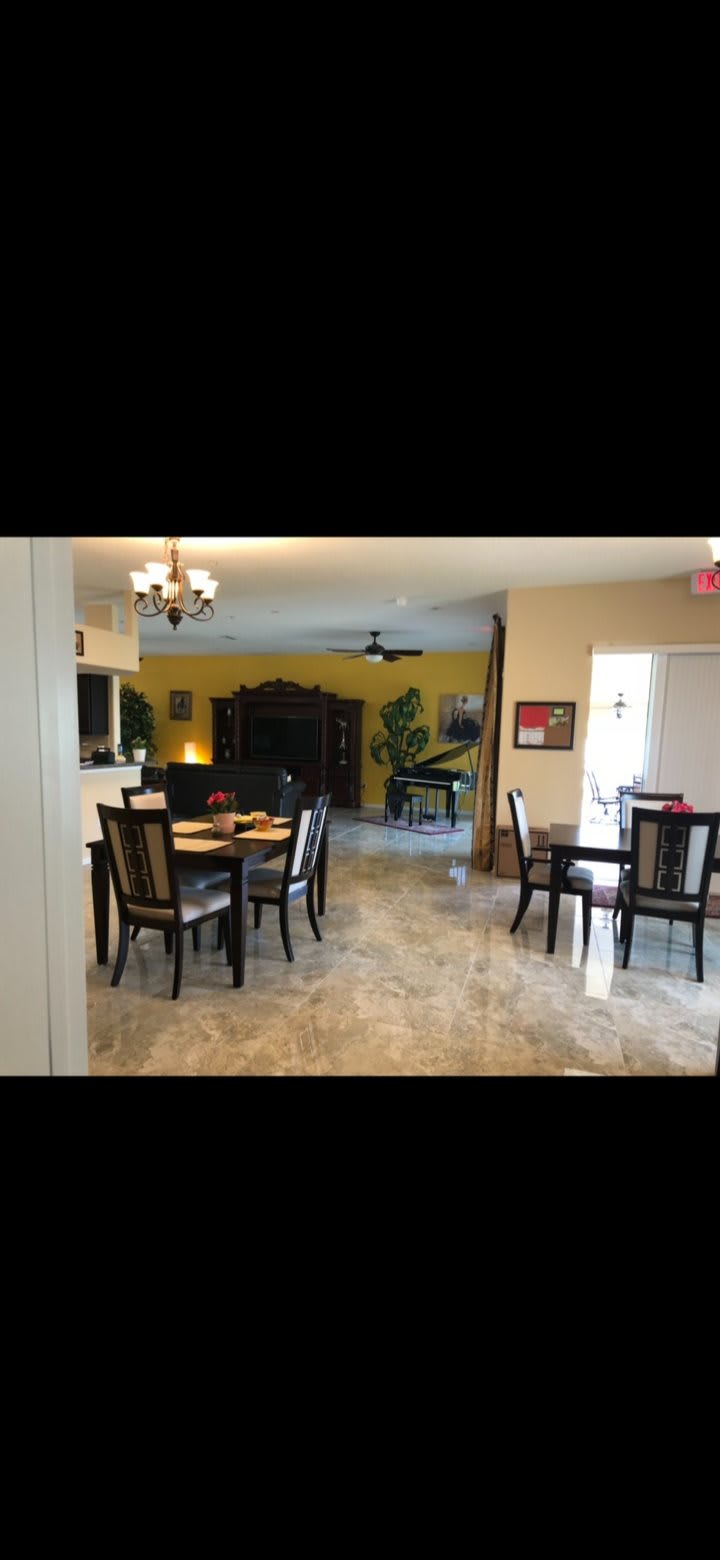 Spacious and elegantly decorated living and dining area with a piano.